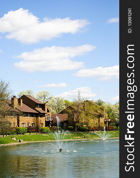 Some apartments by a lake on a blue sky day. Some apartments by a lake on a blue sky day.