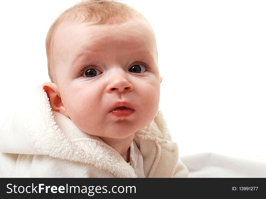 Beautiful baby girl in bathrobe on white background