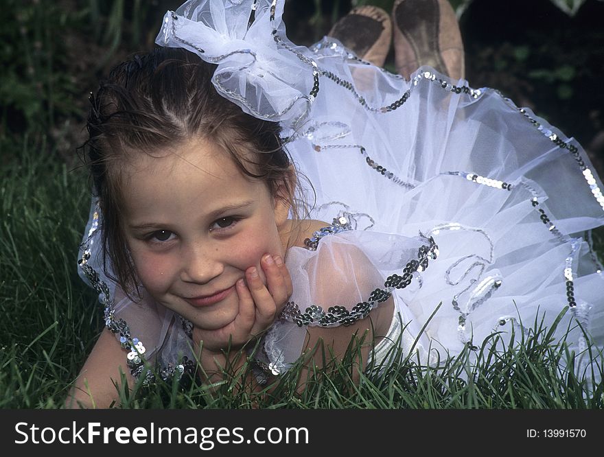 Young girl lying in grass in ballerina costume. Young girl lying in grass in ballerina costume.