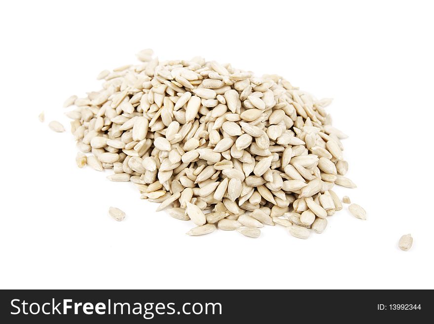 Pile of raw sunflower seeds on a reflective white background. Pile of raw sunflower seeds on a reflective white background