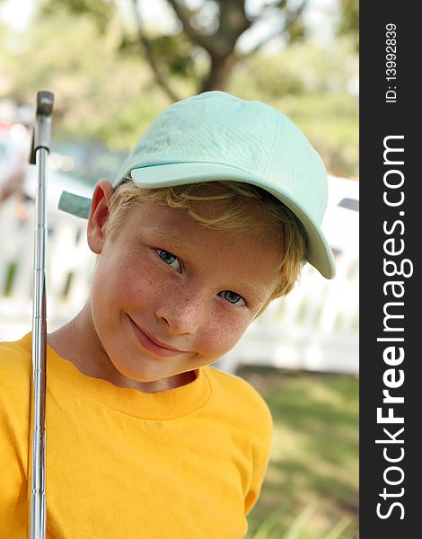 Young boy rests golf club on shoulder. Young boy rests golf club on shoulder