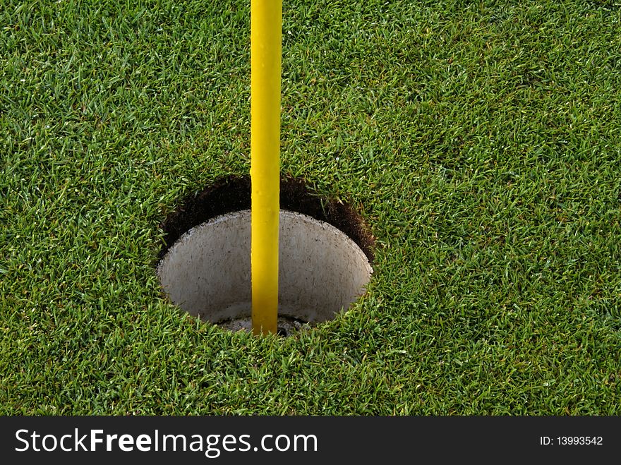 Golf course hole with yellow flagpole. Golf course hole with yellow flagpole