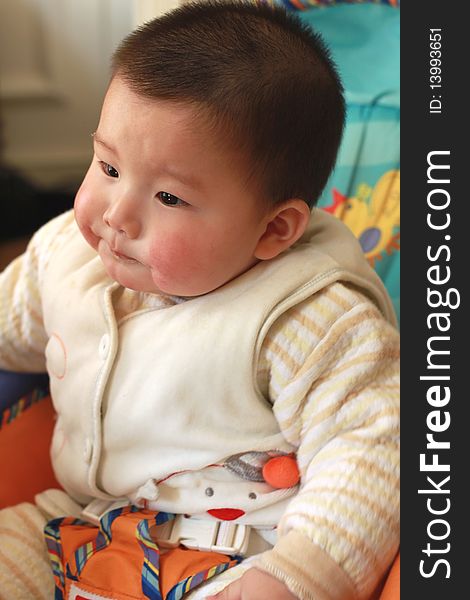 Lovely Chinese baby sitting on a chair. Lovely Chinese baby sitting on a chair