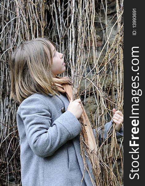 White child having fun with vegetation, old wall in background. White child having fun with vegetation, old wall in background