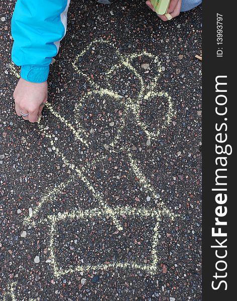 Girl drawing with chalk on asphalt. Girl drawing with chalk on asphalt