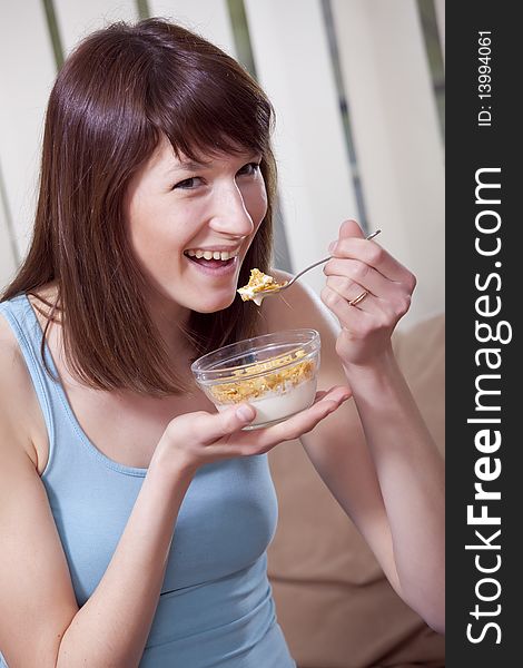 Happy young woman eating tasty corn flakes. Happy young woman eating tasty corn flakes