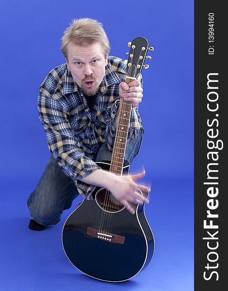 Studio portrait of man playing guitar in funny way. Studio portrait of man playing guitar in funny way.