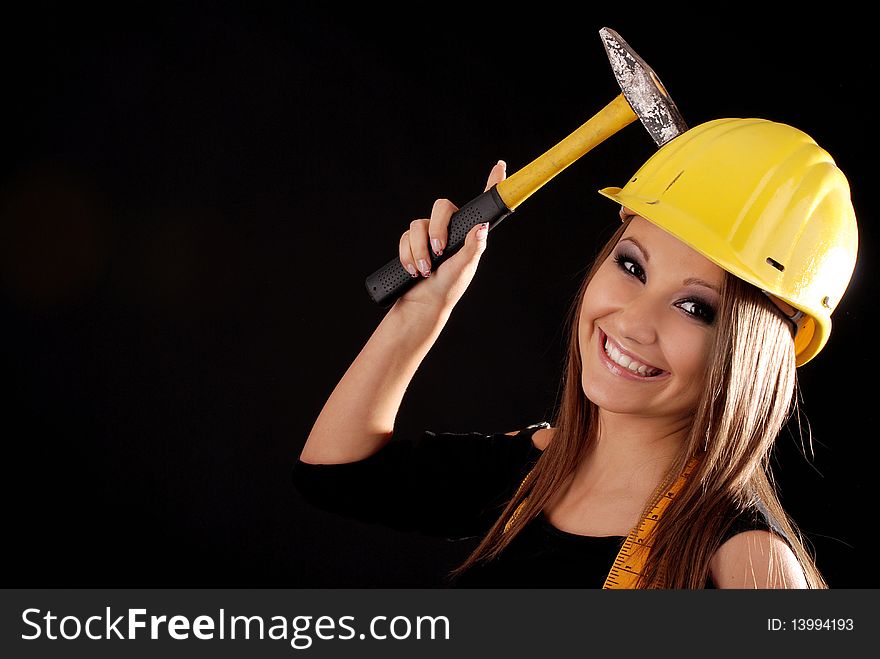 Builder girl with a hammer in hand, helmet on head. Builder girl with a hammer in hand, helmet on head.