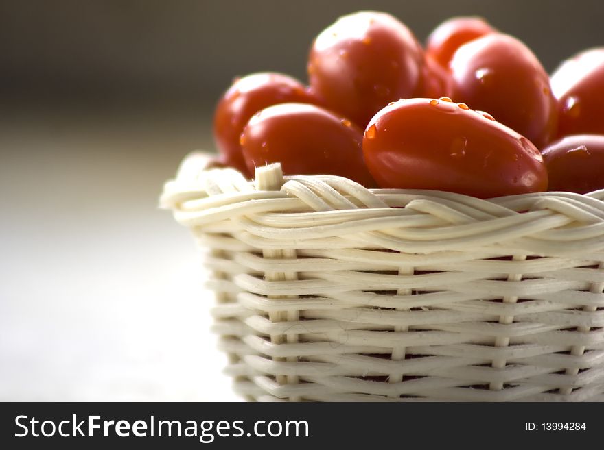 Grape tomatoes in basket with white background