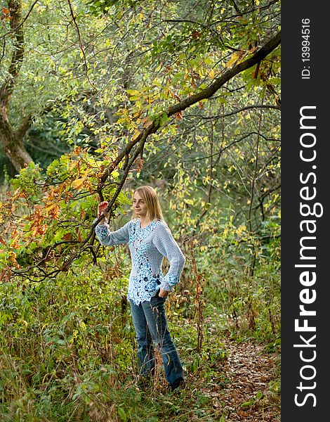 Sunburned girl in blue pullover in the forest