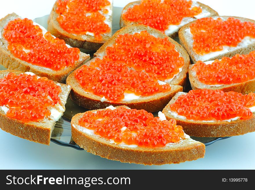 Bread with butter and red caviar on a plate. Bread with butter and red caviar on a plate