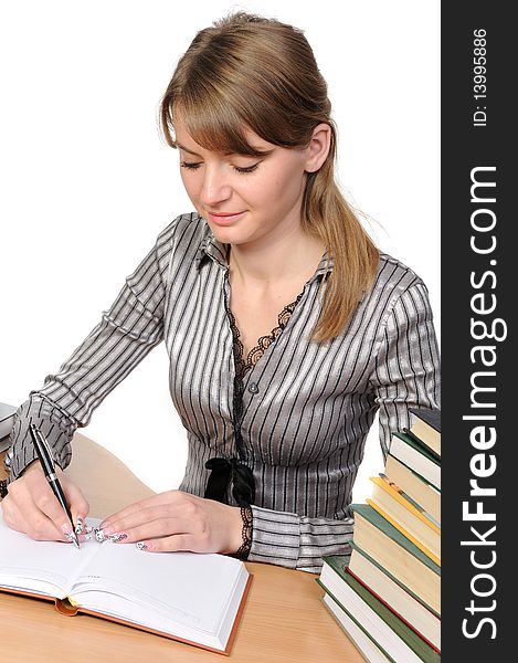 Beauty woman with long hair sits at a table with the book and writes. Beauty woman with long hair sits at a table with the book and writes