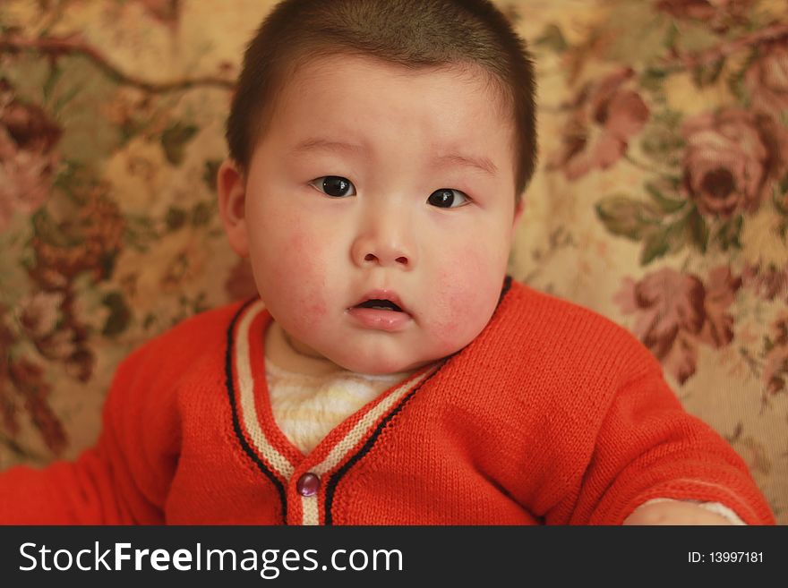 Lovely Chinese baby sitting on a chair. Lovely Chinese baby sitting on a chair