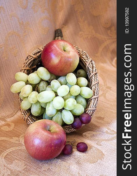 Fruits in a basket on a brocade textile