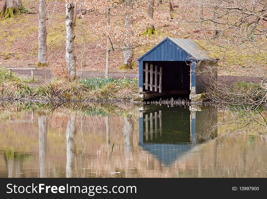 An old boathouse on the edge of the lake at Wallington. With reflection of the structure and the surrounding silver birch trees. An old boathouse on the edge of the lake at Wallington. With reflection of the structure and the surrounding silver birch trees.