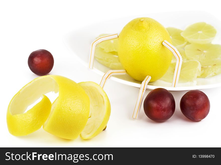 Lemon, segments of a lemon and red plums. Isolated on white.