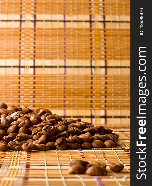 Coffee beans, lying on the straw-mat apart from other coffee beans