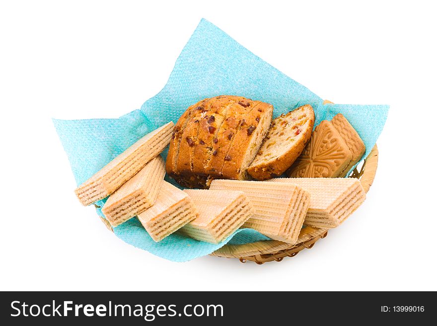 Wafers, a fruitcake and cookies in a wattled basket on a white background