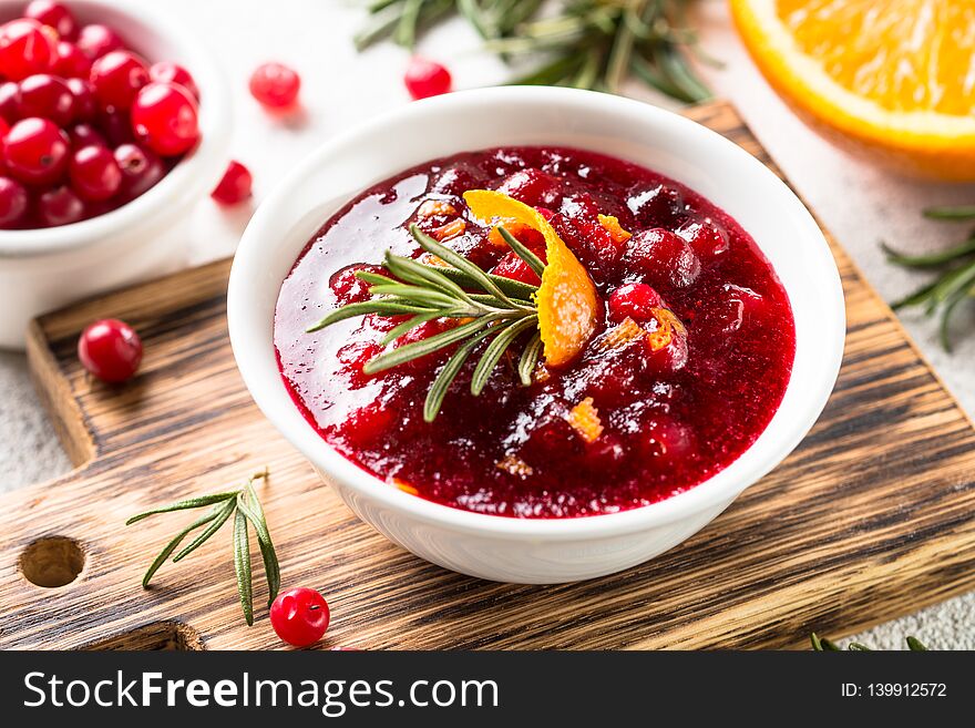 Cranberry sauce or cranberry jam with orange and rosemary. Close up. Cranberry sauce or cranberry jam with orange and rosemary. Close up.