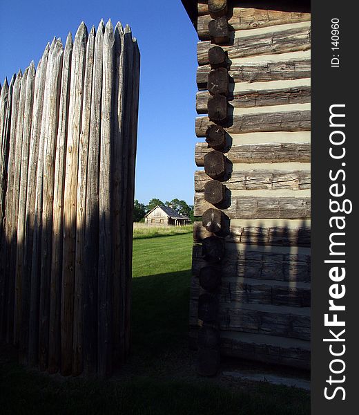 Black smith shop seen through the crack in fence surrounding fort. Black smith shop seen through the crack in fence surrounding fort