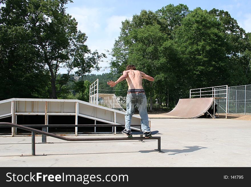 Teen boy shirtless in jeans skateboarding at outdoor skatepark. Shot with the Canon 20D. Teen boy shirtless in jeans skateboarding at outdoor skatepark. Shot with the Canon 20D.