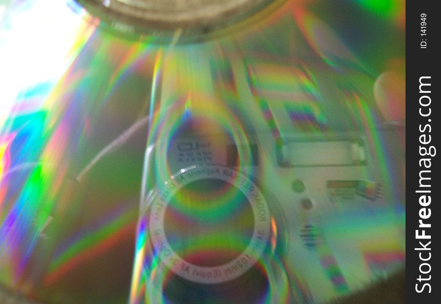 Closeup of a CD with sunlight bouncing off, creating a prism effect.