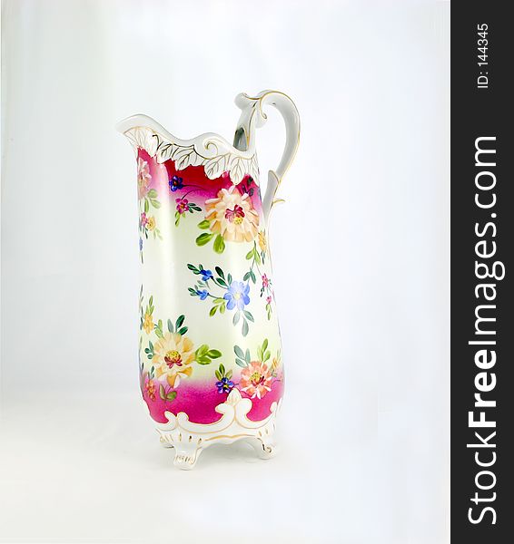 My grandmother's tall pitcher, decorated with flowers, curved handle and spout