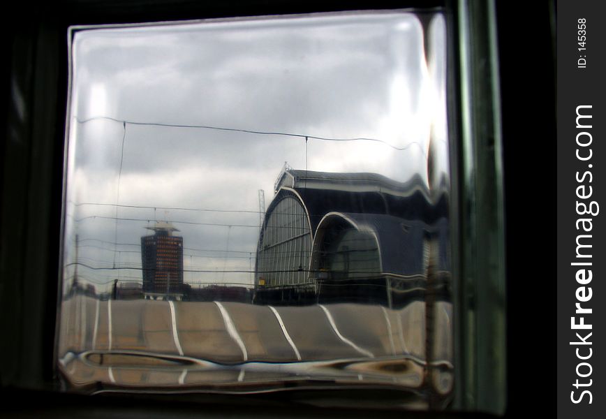 Distorted view of a railway station through a glass brick. Distorted view of a railway station through a glass brick