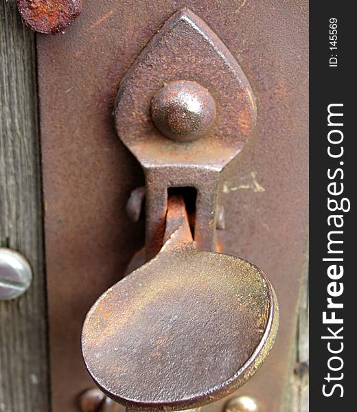 Rusty old gate latch on an old wooden gate