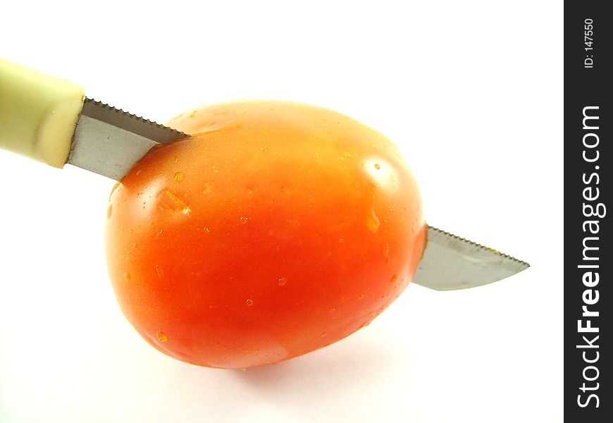A knife through a tomato. A knife through a tomato