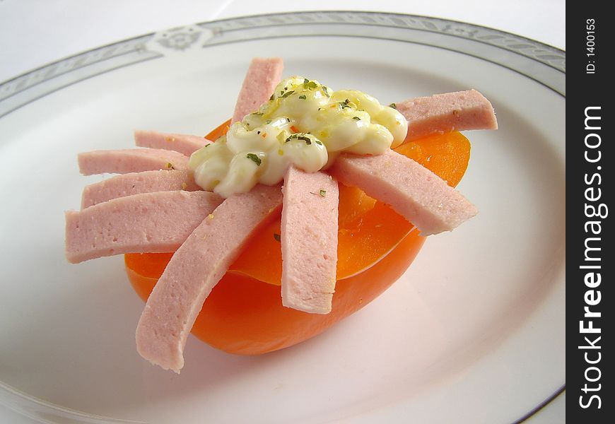 Gourmet dish with orange paprika and salami, decorated with mayonnaise dressing. Gourmet dish with orange paprika and salami, decorated with mayonnaise dressing