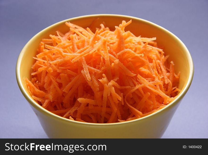 Grated carrots in a yellow plate. Grated carrots in a yellow plate.