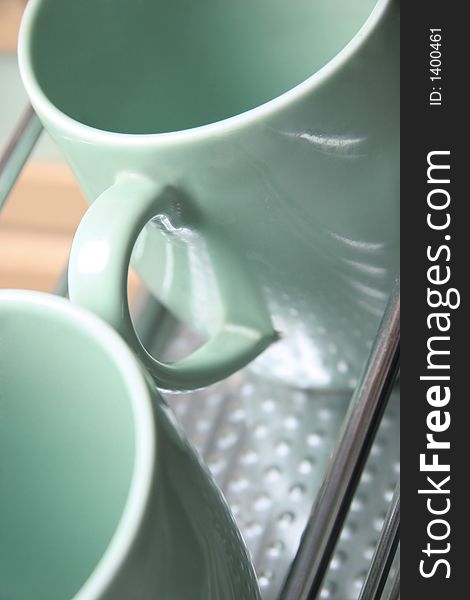 Two green cups on a iron shelf. Two green cups on a iron shelf.