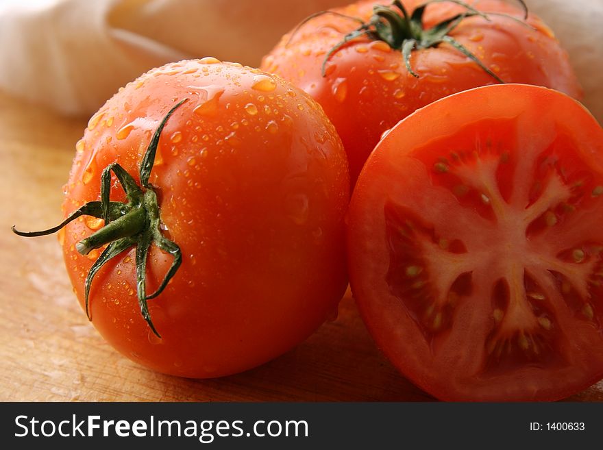 Three tomatoes on a wooden board. Three tomatoes on a wooden board.