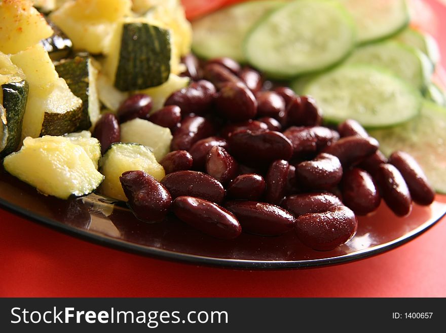 Vegetarian dish. Beans, fried marrows, fresh tomatoes and cucumbers.