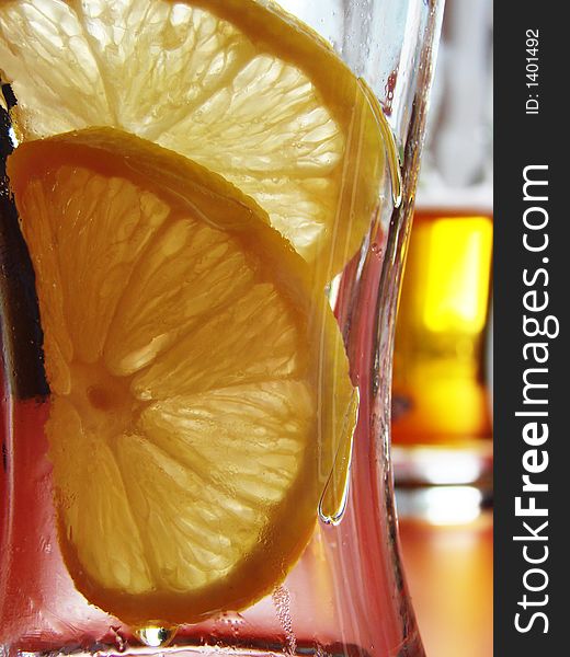 Empty glass from beer with 2 lemon pieces on background with next, full one. Empty glass from beer with 2 lemon pieces on background with next, full one.