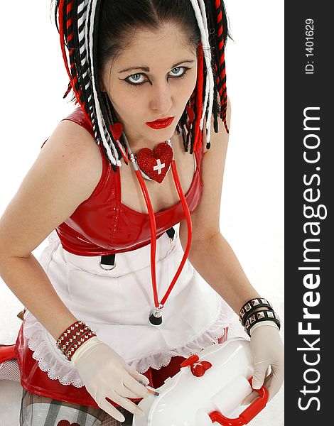 Beautiful young goth nurse sitting, pulling syringe out of medical case.