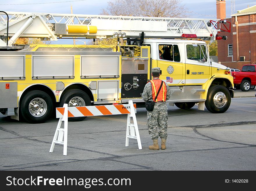 A firetruck responds to an emergency while a national guardsman blocks traffic. A firetruck responds to an emergency while a national guardsman blocks traffic.