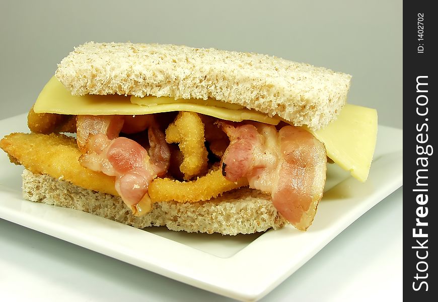 Wholemeal bread sandwich whit breaded breast, bacon and cheese