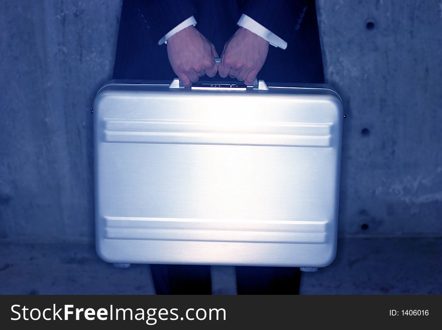 Businessman holds his briefcase in front of his body for security. Businessman holds his briefcase in front of his body for security