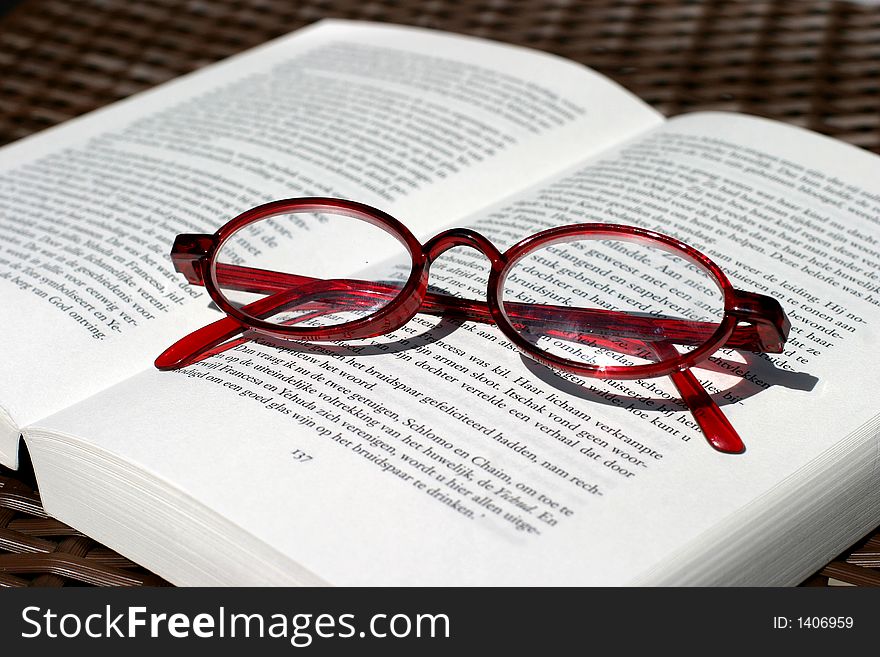 Red reading glasses and book. Red reading glasses and book