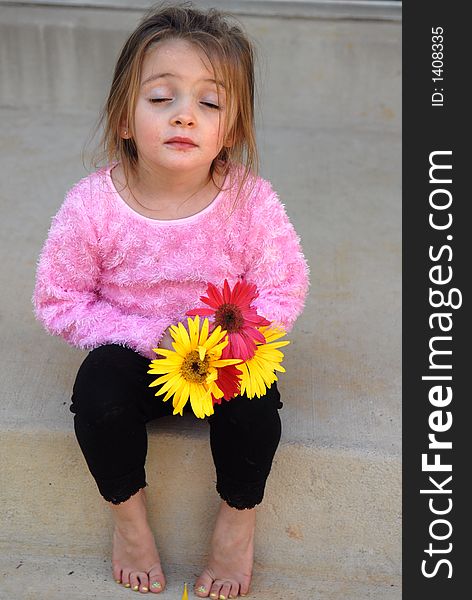 A little girl holding a bouquet of Gerber Daisies she picked from her mother's garden thinking she might be in a little bit of trouble. A little girl holding a bouquet of Gerber Daisies she picked from her mother's garden thinking she might be in a little bit of trouble.