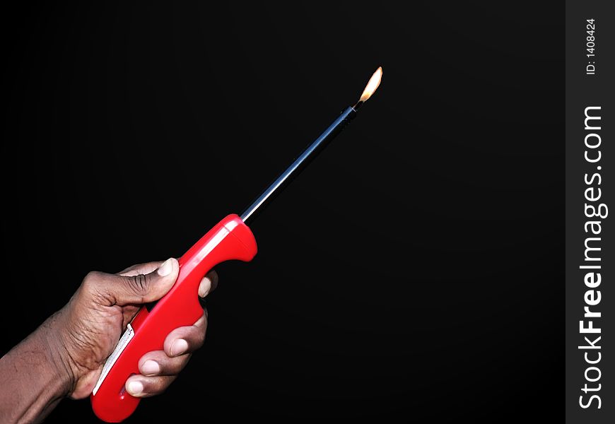 Photo of a hand holding a butane lighter isolated over a black background by a clipping path. Photo of a hand holding a butane lighter isolated over a black background by a clipping path