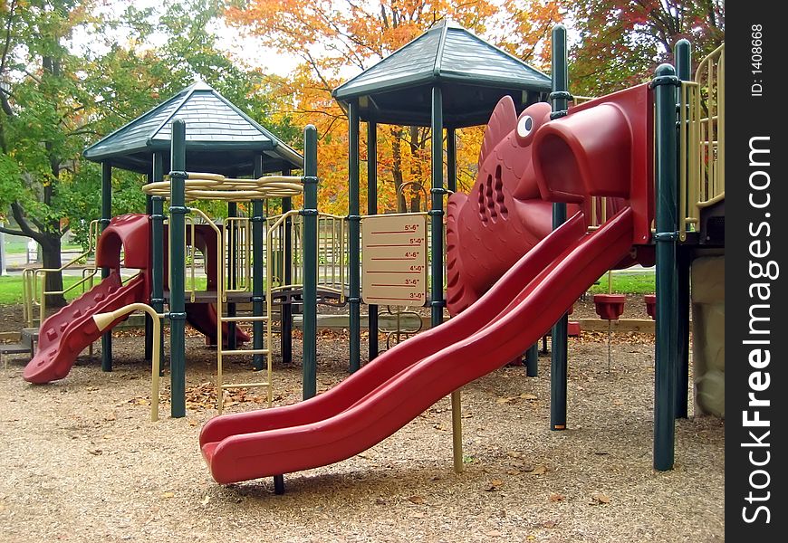 Playground in Autumn with Two Red Sliding Boards. Playground in Autumn with Two Red Sliding Boards