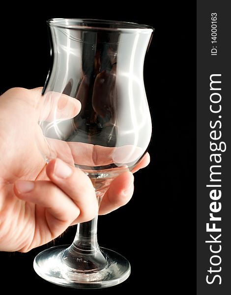 A wineglass in a hand isolated on black