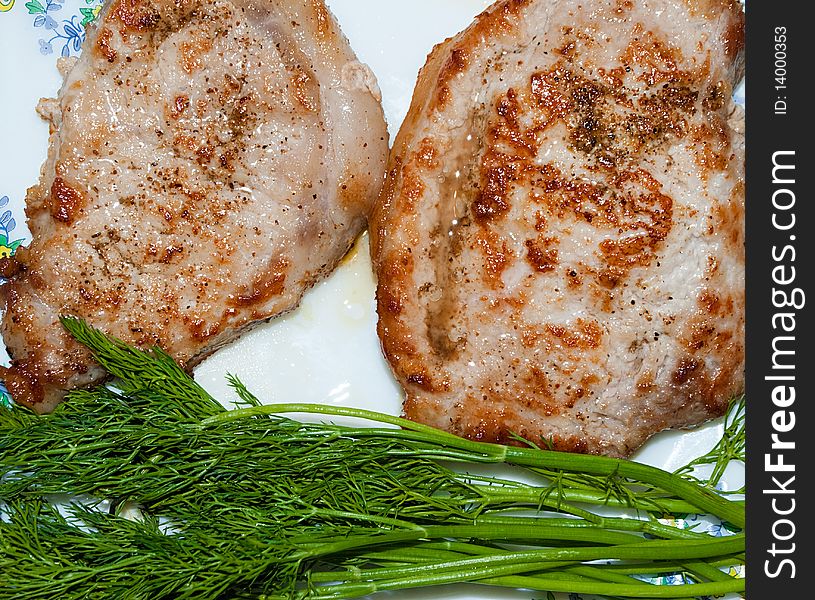 Pieces Of Juicy, Fried Meat With Greens