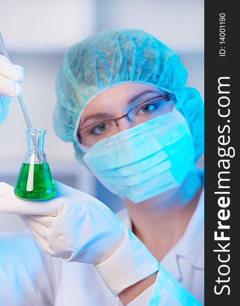 Closeup of a female researcher holding up a test tube and a retort in the laboratory