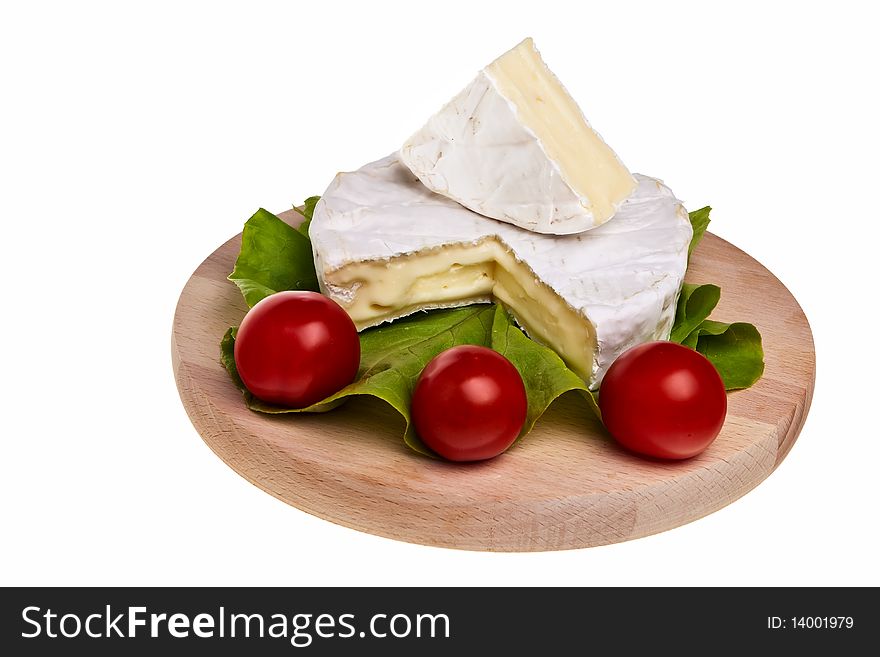 Round camembert cheese on wooden board with lettuce and tomatoes. Round camembert cheese on wooden board with lettuce and tomatoes.