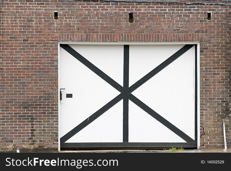 Large white wooden door on brick building. Large white wooden door on brick building.