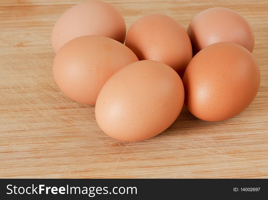 Six fresh poultry eggs on timber board. Six fresh poultry eggs on timber board.
